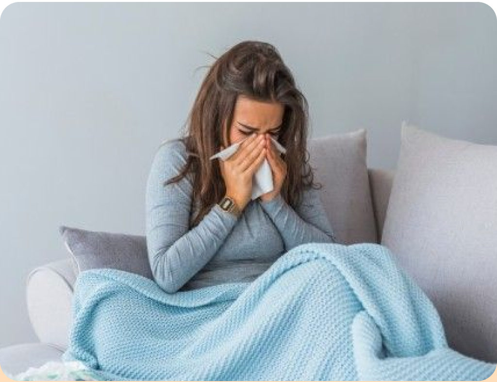 A woman wrapped in a blanket with a cold